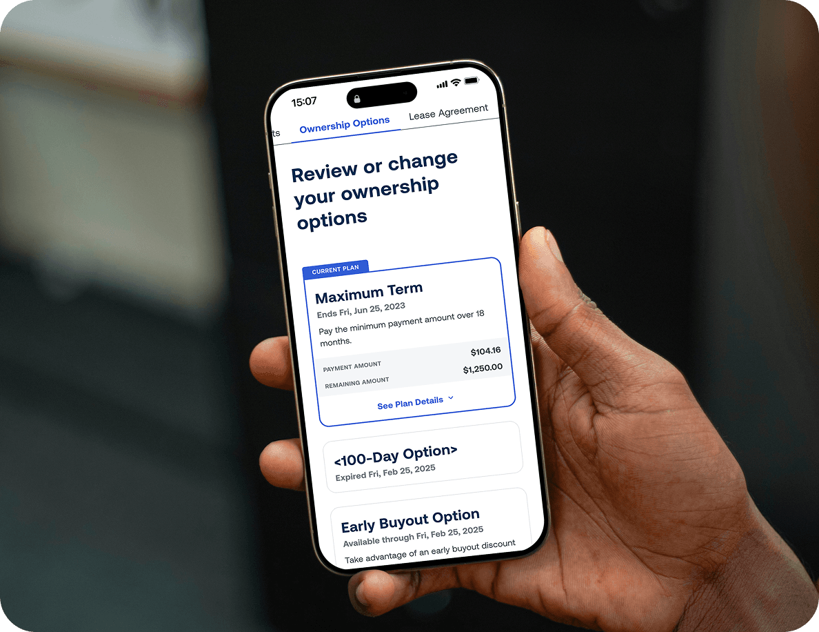 A hand holds a smartphone displaying a screen with options to review or change ownership plans, including details of a maximum term and buyout options.