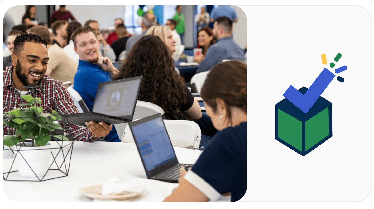 People at a table working on laptops, smiling and engaged, with a decorative green and blue checkmark icon on the right.