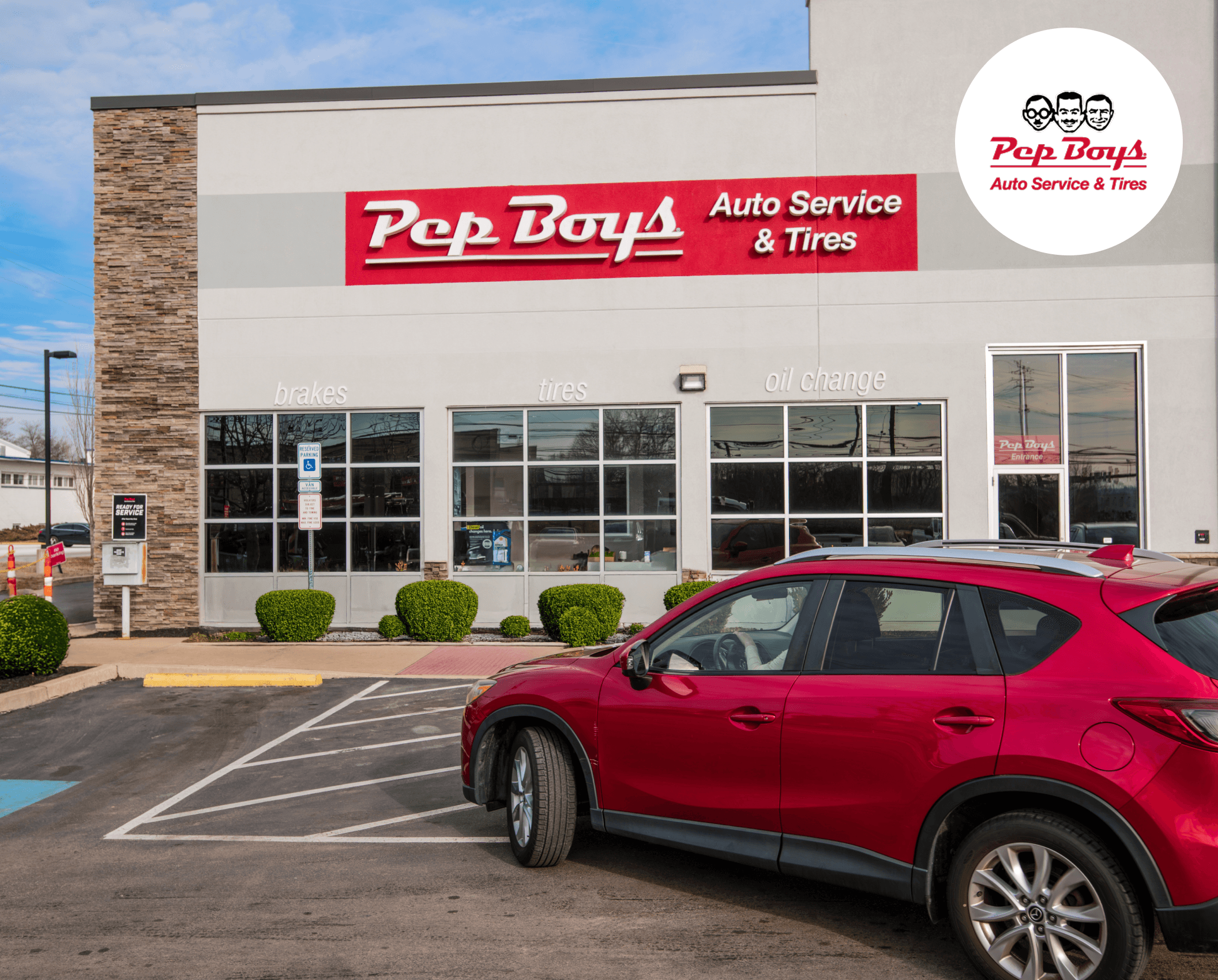 A red SUV parked in front of a Pep Boys Auto Service & Tires store, with signs for brakes, tires, and oil change visible on the window.