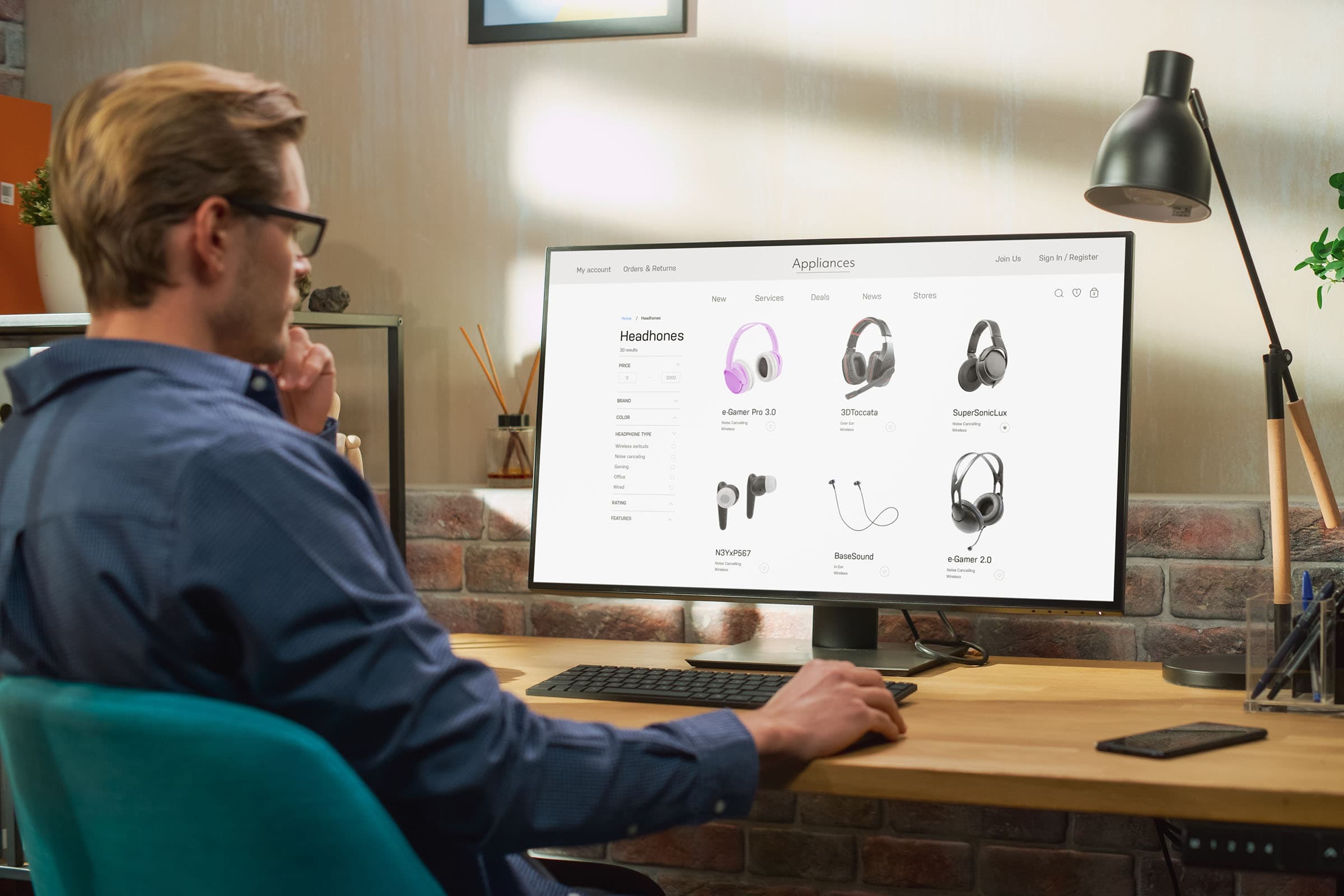 Man in blue shirt browsing headphones on a large desktop monitor in a modern, well-lit office setting.