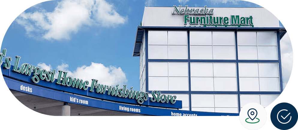 Exterior of Nebraska Furniture Mart building with large signage against a blue sky with clouds.