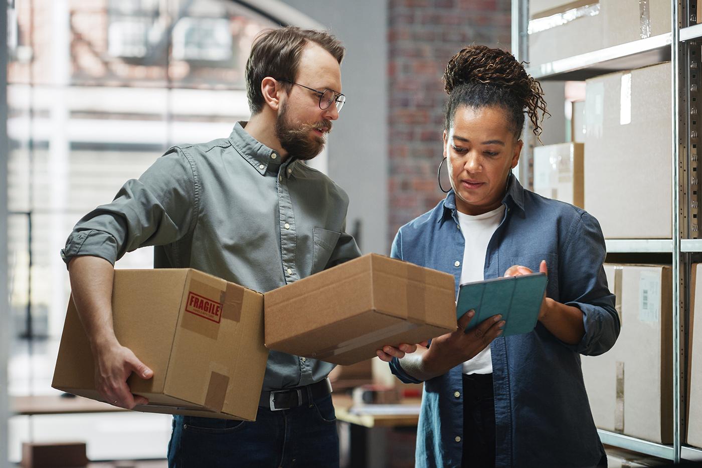 two people in a warehouse reviewing inventory information