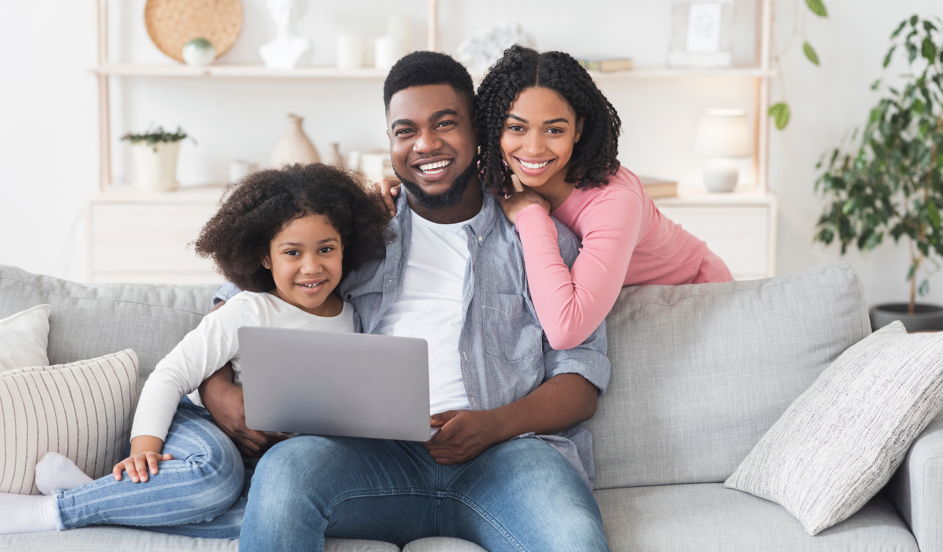 Family sitting on couch with laptop