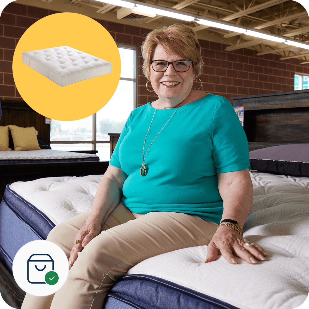 Smiling woman sitting on a mattress in a store, with an image of a mattress overlay and a shopping icon with a checkmark.